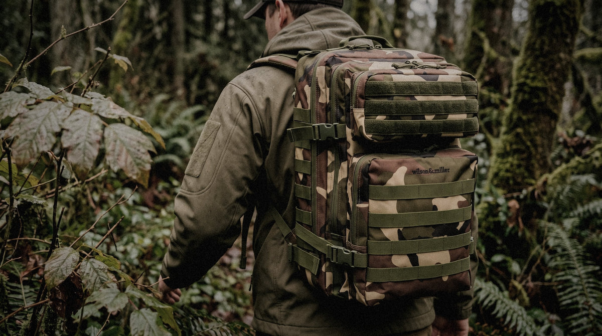 A Garrison 45L in woodland camo carried through a green forest