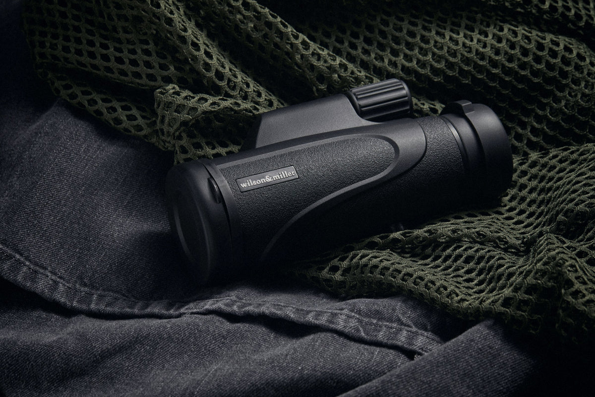 TacticalEye monocular resting on olive mesh and dark canvas